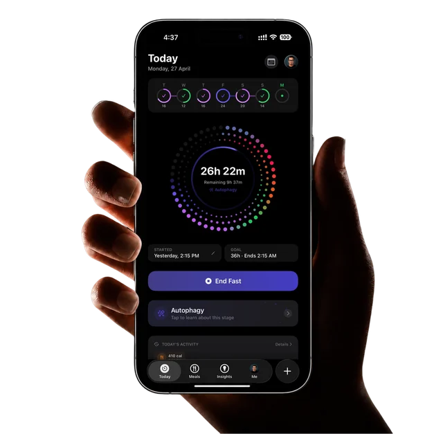 A hand holding an iPhone showing the Atomic Fast Today screen: a 36-hour fast at 26h 22m in Autophagy, its dotted ring colored phase by phase, with an End Fast button